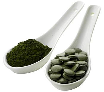 tva vita skedar fyllda med gront chlorella pulver och grona chlorella tabletter tva vita skedar fyllda med gront chlorella pulver och grona chlorella tabletter