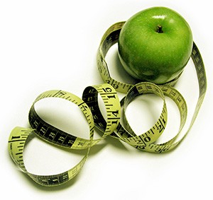 ett gront apple med ett gult och svart mattband runtomkring mot en vit bakgrund