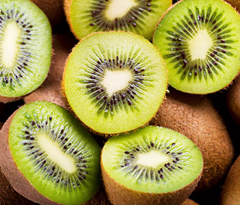 Bild på massvis med kiwis, nagra är hela och nagra är skurna till halften