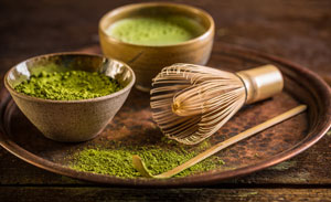 Image of Matcha Tea powder with bamboo whisk and bamboo scoop