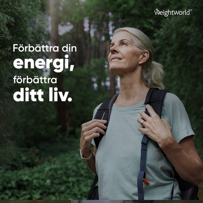 Bilden visar en leende kvinna som går en promenad i skogen