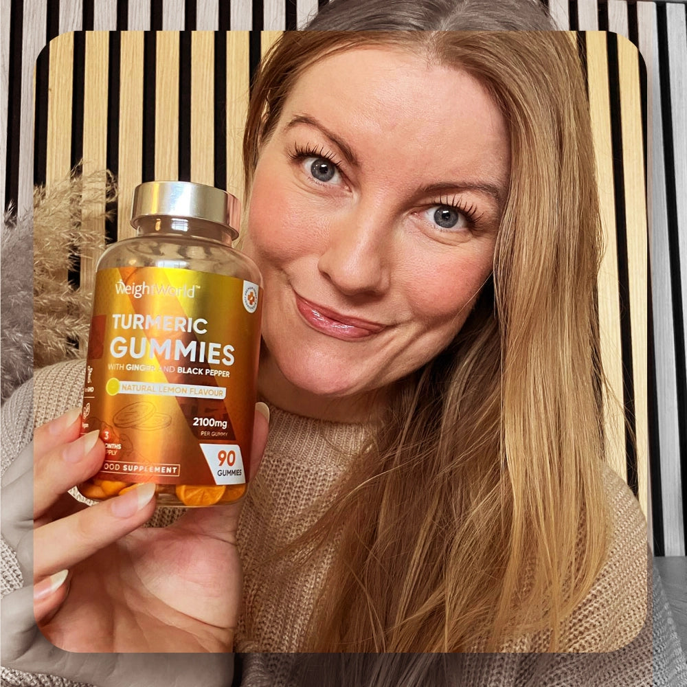 Gurkmeja Gummies-flaska i kvinnas hand med orange etikett