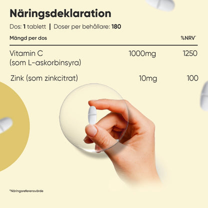 Vitamin C- och zinktabletter, hand håller vit tablett över näringsdeklaration.